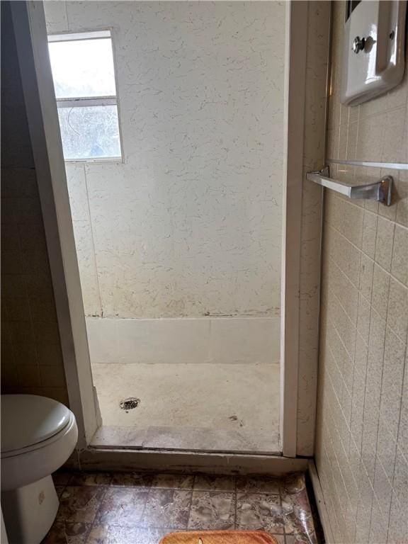 bathroom featuring walk in shower and toilet