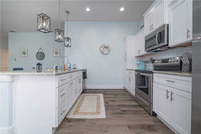 kitchen featuring white cabinets, appliances with stainless steel finishes, and wood-type flooring