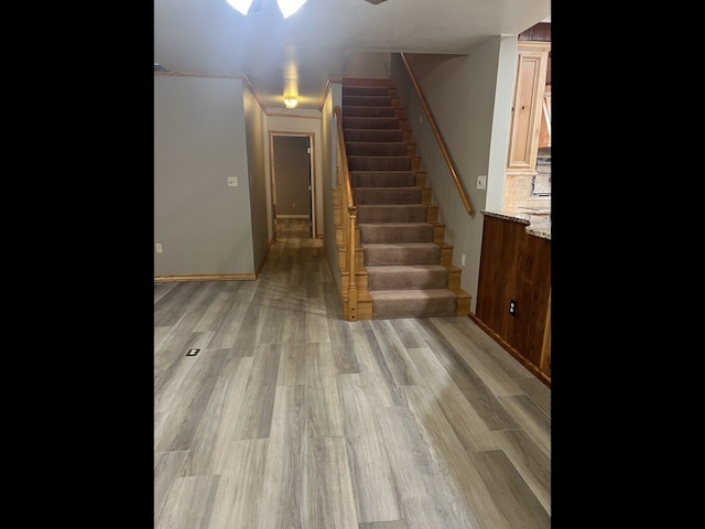 staircase featuring hardwood / wood-style floors and ornamental molding