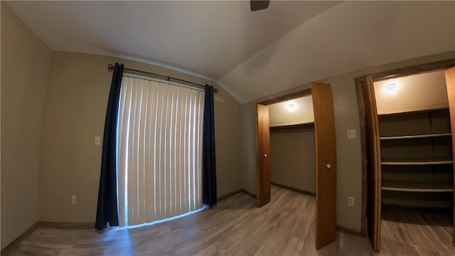 interior space featuring lofted ceiling and light hardwood / wood-style flooring