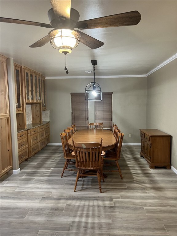 dining room featuring ceiling fan, light hardwood / wood-style floors, and ornamental molding