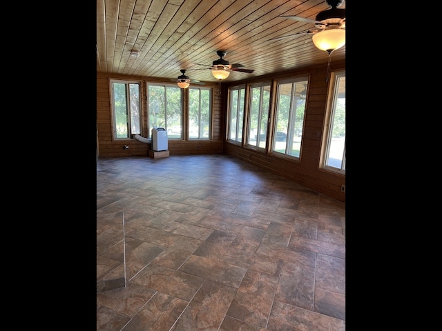 unfurnished sunroom with ceiling fan and wooden ceiling