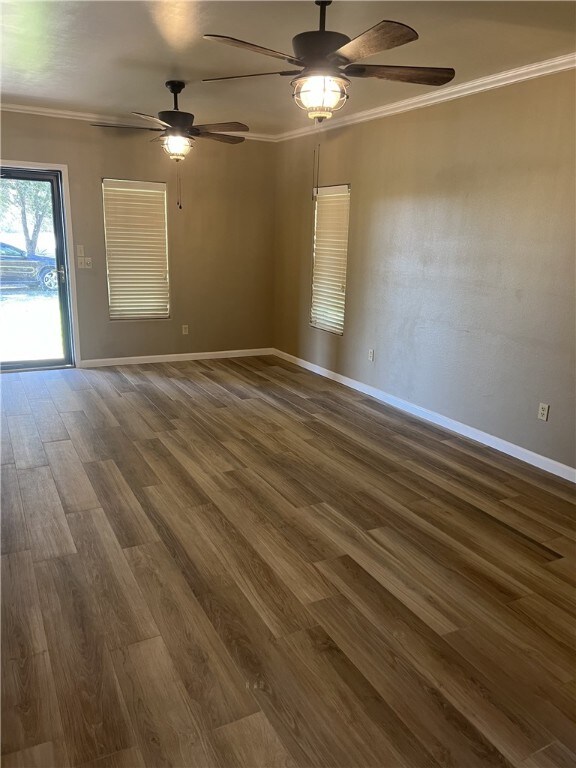 spare room featuring dark hardwood / wood-style floors, ceiling fan, and crown molding