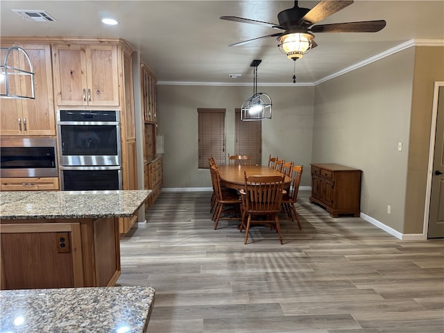 dining space featuring hardwood / wood-style flooring, ceiling fan, and crown molding