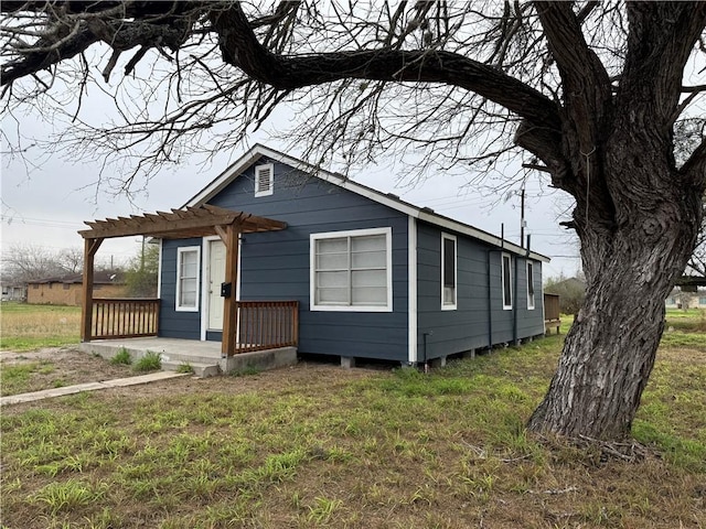 view of front of property featuring a front yard and a pergola