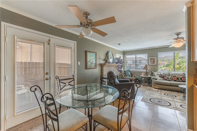 dining space featuring ceiling fan, ornamental molding, a textured ceiling, and light tile patterned floors