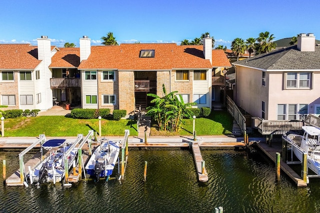 view of dock featuring a lawn and a water view