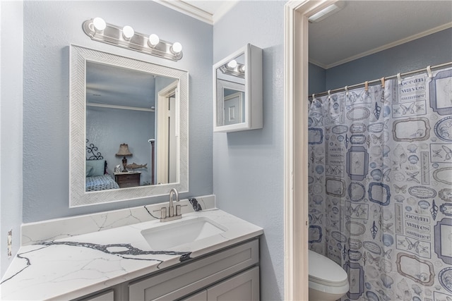 bathroom with vanity, toilet, ornamental molding, and walk in shower