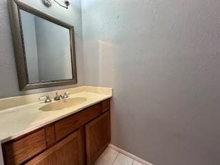bathroom featuring tile patterned floors, baseboards, and vanity