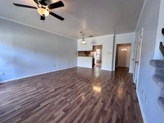 unfurnished living room featuring ornamental molding, ceiling fan, and wood finished floors