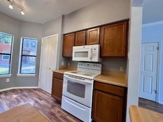 kitchen featuring white appliances, brown cabinets, a healthy amount of sunlight, and light countertops