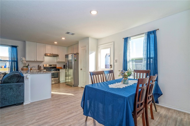 dining area with light hardwood / wood-style floors and sink