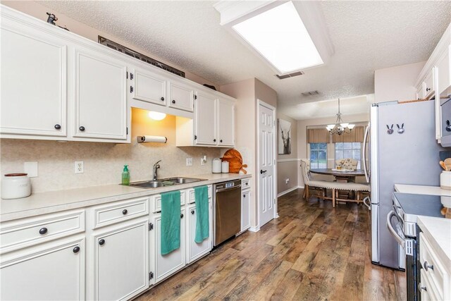 6309 Brianna Cir, Corpus Christi, TX 78414 - kitchen with stainless steel appliances, a chandelier, white cabinetry, backsplash, and dark wood-type flooring