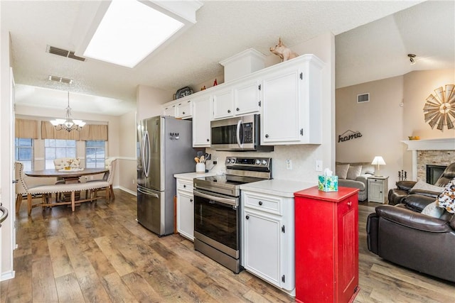 6309 Brianna Cir, Corpus Christi, TX 78414 - kitchen featuring stainless steel appliances, a chandelier, open floor plan, white cabinetry, and light countertops
