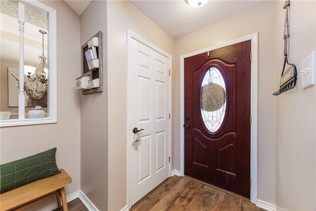 6309 Brianna Cir, Corpus Christi, TX 78414 - foyer with dark wood-style floors, a textured ceiling, and a chandelier