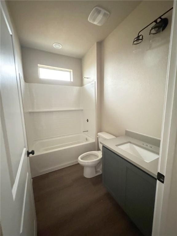 bathroom featuring toilet, vanity, wood finished floors, and bathing tub / shower combination