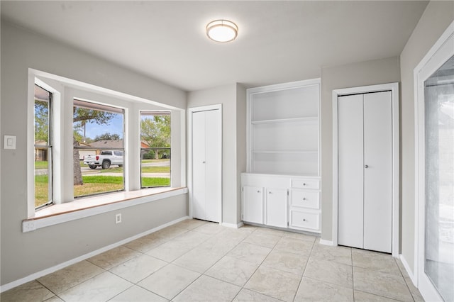 unfurnished bedroom featuring multiple closets and light tile patterned flooring