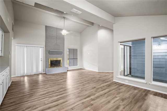 unfurnished living room featuring hardwood / wood-style floors, high vaulted ceiling, a fireplace, and beamed ceiling