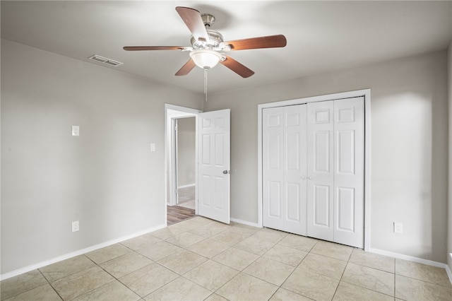 unfurnished bedroom featuring light tile patterned floors, a closet, and ceiling fan