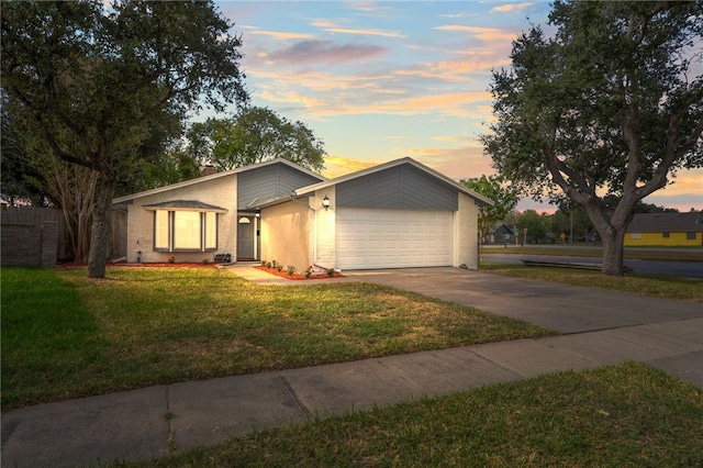 ranch-style house featuring a yard and a garage