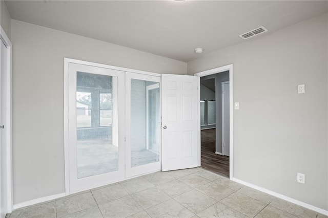 unfurnished bedroom with french doors