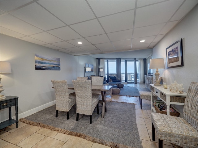 tiled dining area featuring a paneled ceiling