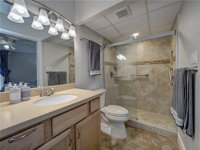 bathroom featuring ceiling fan, vanity, toilet, and an enclosed shower