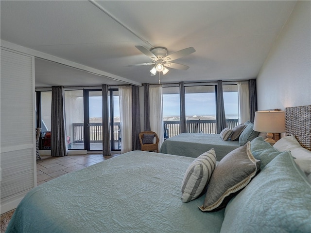 tiled bedroom featuring access to outside, a wall of windows, and ceiling fan