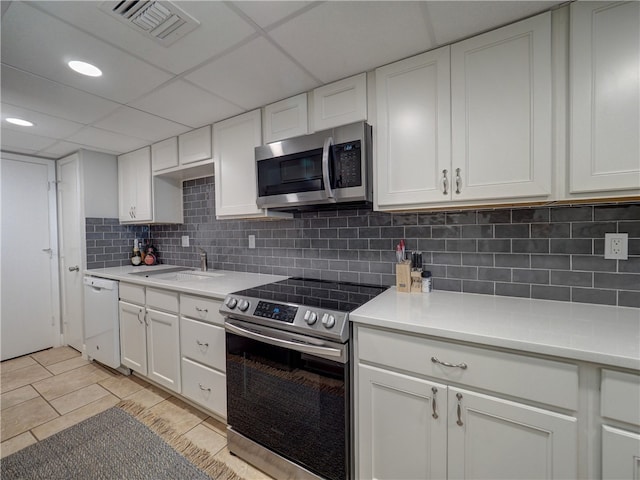 kitchen with white cabinetry, appliances with stainless steel finishes, sink, and light tile patterned floors