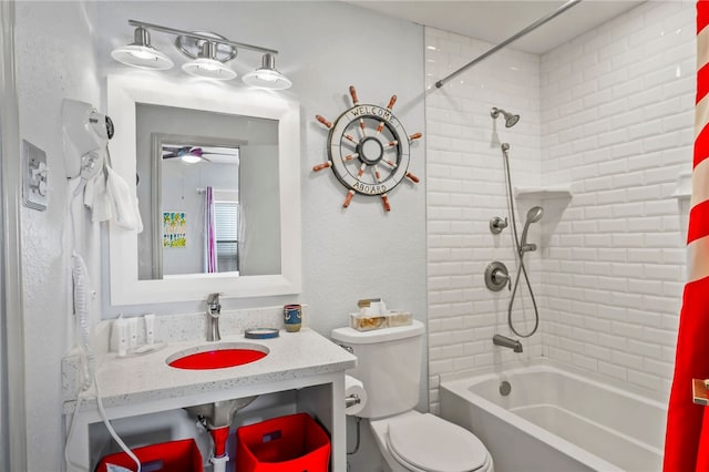 full bathroom featuring ceiling fan, sink, toilet, and tiled shower / bath combo