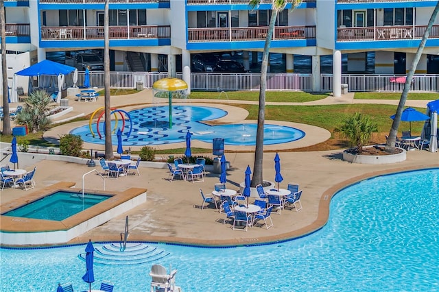 view of swimming pool featuring a yard, a patio, and a hot tub