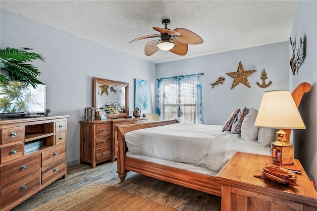 bedroom with wood-type flooring, ceiling fan, and a textured ceiling