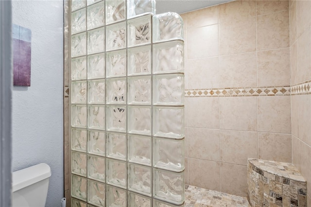 bathroom with toilet and tiled shower