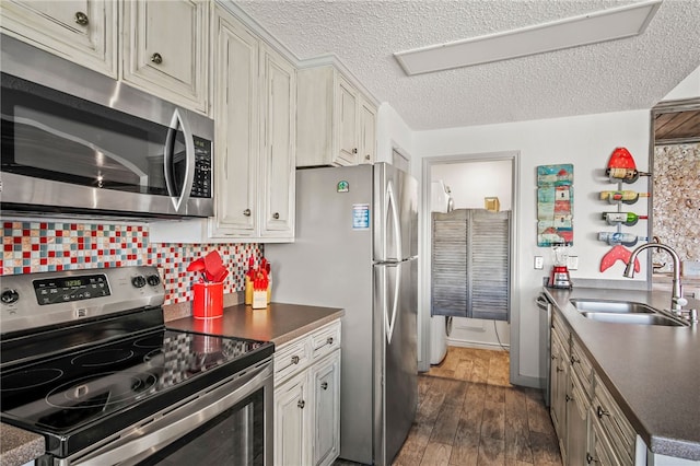 kitchen featuring stainless steel appliances, sink, tasteful backsplash, a textured ceiling, and dark hardwood / wood-style flooring