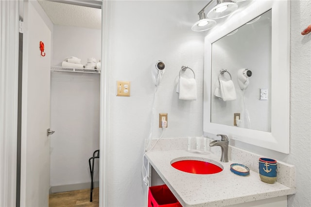 bathroom featuring hardwood / wood-style floors, vanity, and a textured ceiling