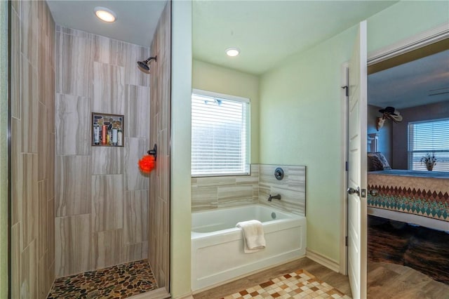 bathroom featuring wood-type flooring, shower with separate bathtub, and a wealth of natural light