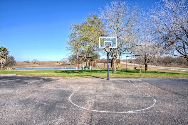 view of sport court with a lawn, a playground, and a water view