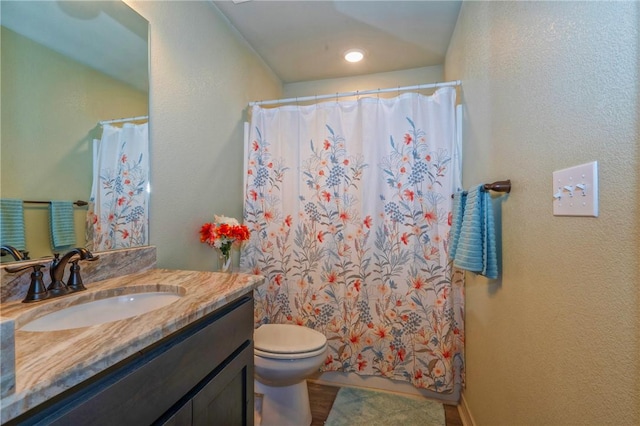 bathroom with vanity, a shower with shower curtain, and toilet