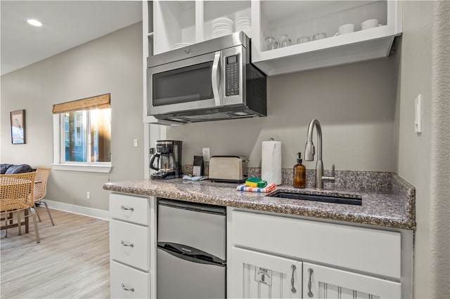 kitchen with white cabinetry, sink, light hardwood / wood-style flooring, and appliances with stainless steel finishes