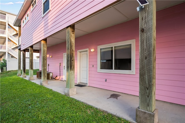 doorway to property with a lawn and a patio area