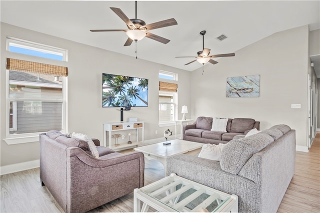 living room featuring light hardwood / wood-style floors, vaulted ceiling, and ceiling fan