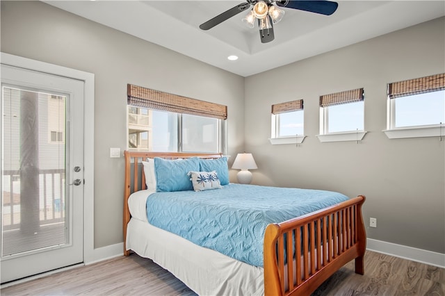 bedroom featuring multiple windows, ceiling fan, and hardwood / wood-style floors