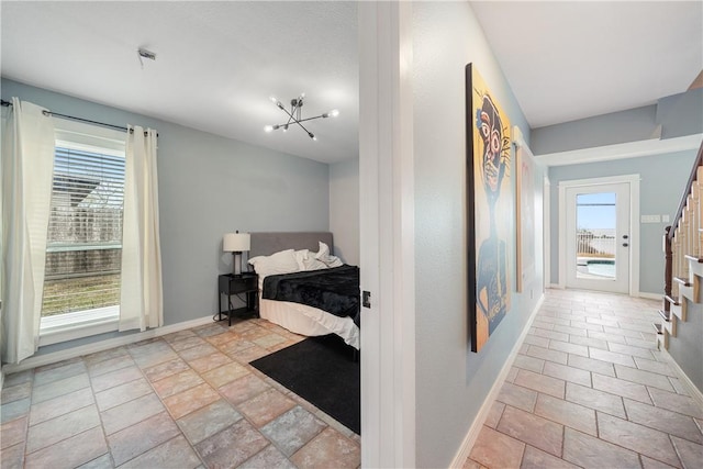 bedroom featuring multiple windows and an inviting chandelier