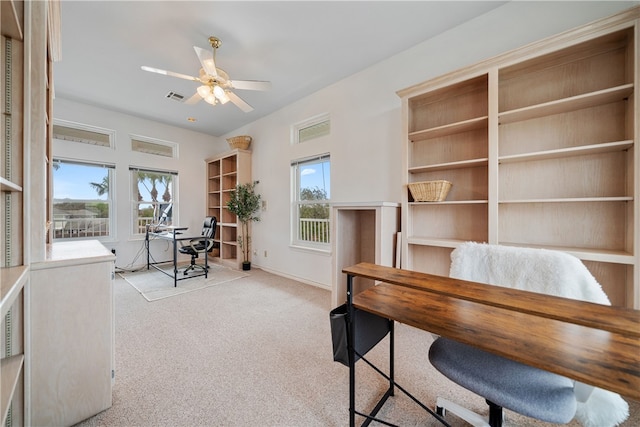 carpeted home office featuring a wealth of natural light and ceiling fan