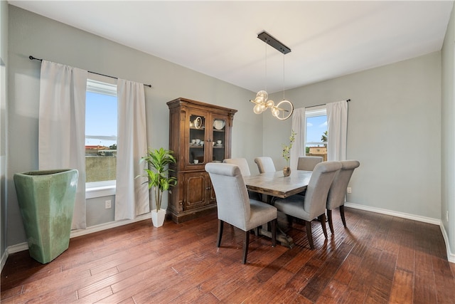 dining area featuring dark hardwood / wood-style floors and an inviting chandelier