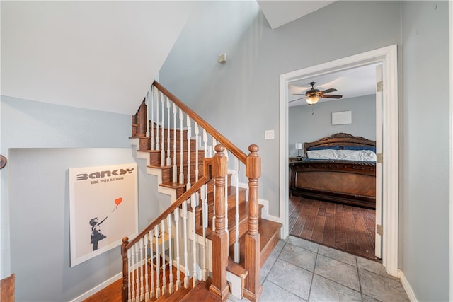 stairway featuring ceiling fan