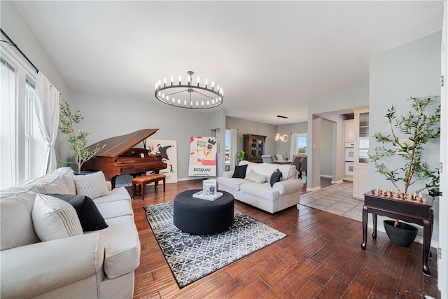 living room featuring a healthy amount of sunlight, wood-type flooring, and a chandelier