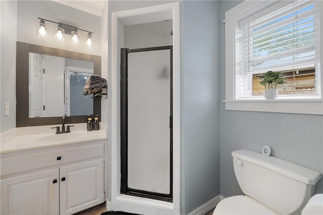 bathroom with an enclosed shower, vanity, and toilet