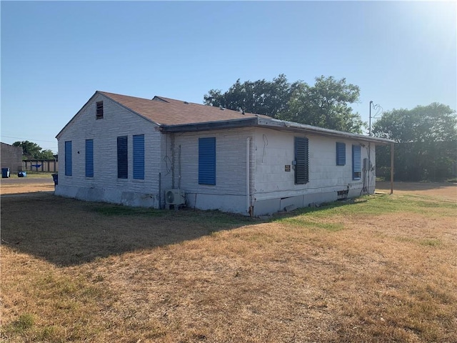 view of side of home with crawl space and a yard