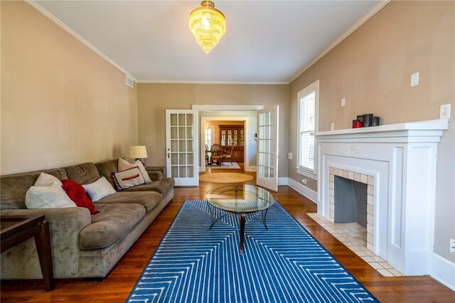 1107 N Adams St, Beeville, TX 78102 - living room featuring french doors, wood finished floors, ornamental molding, baseboards, and a tile fireplace